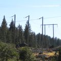 On older power lines with wooden towers, bends are often constructed this way, especially at high altitudes: each cable is carried on a separate guyed pole (in the background, a regular two-legged tower). Since the entire power line is mapped as a single way (with cables=3), I tagged the trio of poles as a single tower, not as three separate poles.