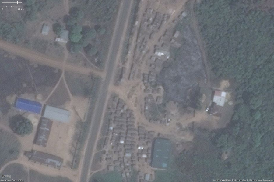 A likely marketplace in a larger West African settlement. The key features are the small buildings tightly packed. There is also one large building that is typically seen in marketplace areas used as a central storage or distribution building. The context also indicates a marketplace makes sense here, a large settlement and an industrial scale housing camp of some sort. This should be tagged amenity=marketplace and fixme=confirm (unless you have first hand knowledge it is a marketplace).