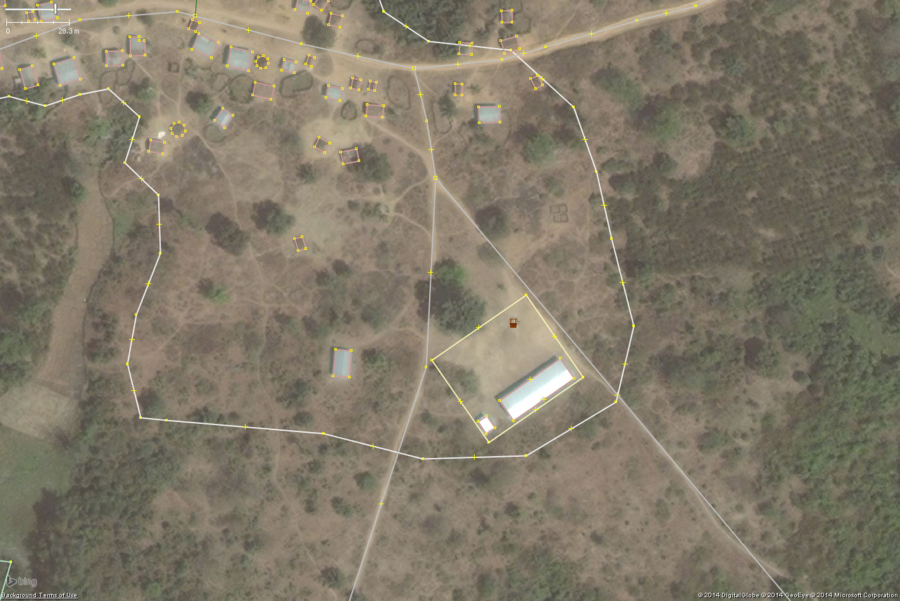 A typical rural school in West Africa. This zoomed in view shows the key features: 1 or 2 long buildings, 1 or 2 smaller toilet buildings, a large bare field. The overall school property should be tagged with amenity=school and the buildings with building=yes.