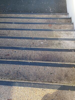 un escalier avec une bande contrastée sur chaque bordure de marche